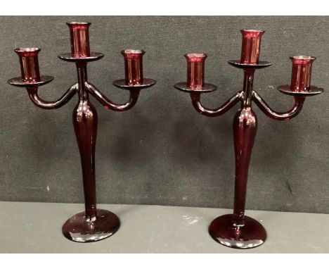 A pair of contemporary three branch ruby glass candlesticks, 34cm high (2).