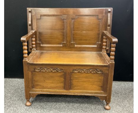 A 17th century style oak monk’s bench, 70.5cm high, 91cm wide, 48cm deep (as a table)