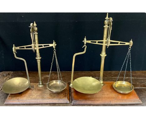 A set of W &amp; T Avery brass 12oz weighing scales, mahogany base;  another similar, W A Webb, London, c.1920, (2).