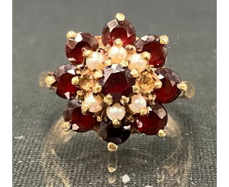 A 9ct gold garnet and cultured pearl floral cluster dress ring, size K/L, 6g gross (2 pearls missing)