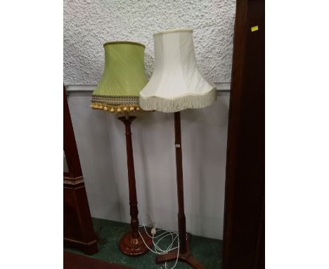 An oak standard lamp with cream tasselled shade and another standard lamp with green shade