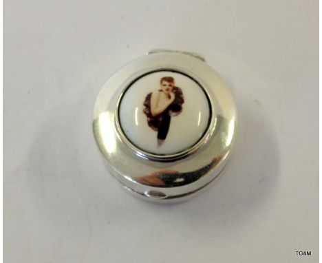 A silver and enamel pill box depicting a young lady