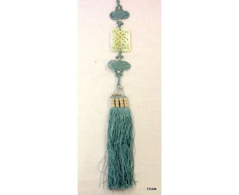 Chinese pale green Jade carving of a knot suspended in an intricate blue silk and tassel cord