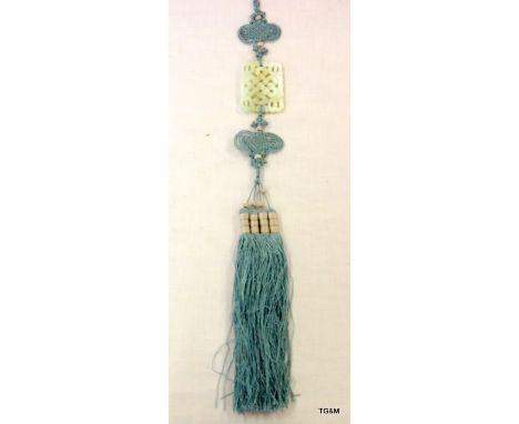 Chinese pale green Jade carving of a knot suspended in an intricate blue silk and tassel cord