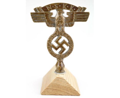 N.S.K.K. BRONZE EMBLEM Small cast bronze N.S.K.K. emblem, possibly a hood ornament, 3.5 in. tall, set upon a modern wood base