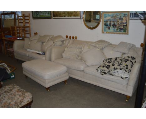 A cream upholstered pouffe together with a pair of matching drop arm settees 