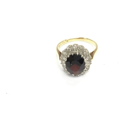 An 18ct garnet and diamond cluster ring. Size N and 5.13g Postage A