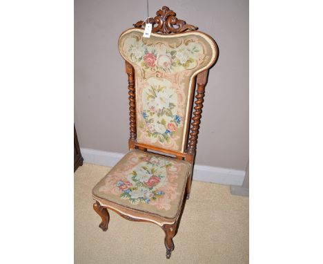 A Victorian walnut chair, the back and seat upholstered in floral tapestry, raised on cabriole legs terminating in ceramic ca