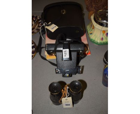 A pair of vintage binoculars; a Polaroid land camera; a pair of modern binoculars in a carrying case; a collection of cards i