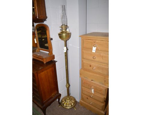 A early 20th Century brass oil lamp on stand, 54in. tall with chimney.