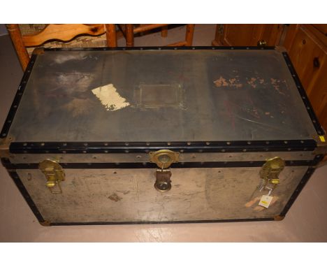 A metal trunk with handles to side, brass effect locks to the front and metal mounts to edges.