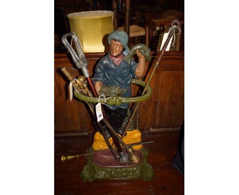 A Victorian style cast iron stick stand in the form of a fisherman, 26in. high; together with a shooting stick; three brass p