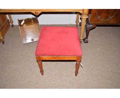 An early 20th Century stool with red upholstered top, raised on turned legs, 20in. diameter.