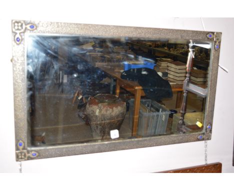An Arts and Crafts rectangular style frame fitted bevelled mirror measures, 17 x 30in. wide.