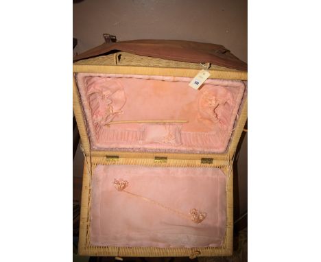 A rectangular wicker basket with lift-up lid fitted with pink interior, fitted tray and a canvas outer carrying case.