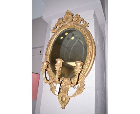 A 19th Century elaborate gilt mirror, fitted with three candlesticks and bevelled mirror, 32in. long.