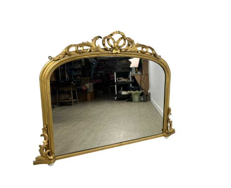 VICTORIAN GILT OVERMANTEL MIRROR, MID 19TH CENTURY  of arched rectangular form with ribbon and scroll pediment128cm wide