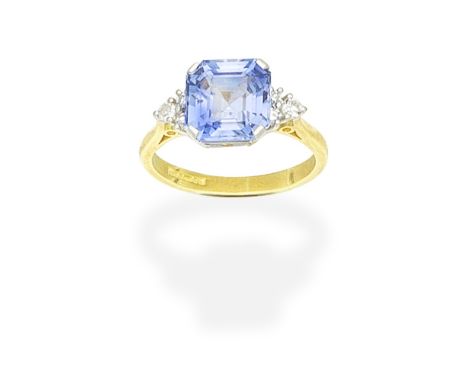 SAPPHIRE AND DIAMOND RINGThe octagonal step-cut sapphire, between trios of single-cut diamonds, mounted in 18 carat gold, UK 