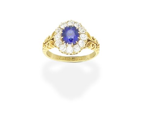 SAPPHIRE AND DIAMOND CLUSTER RING, CIRCA 1900The cushion-shaped sapphire within a cushion-shaped diamond surround, between op