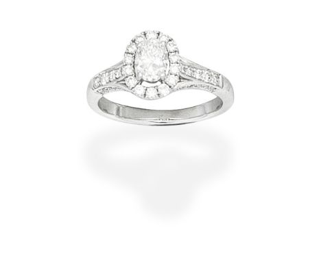 DIAMOND CLUSTER RINGThe oval-cut diamond, weighing 0.54 carat, within a brilliant-cut diamond-set mount, ring size L-MFootnot