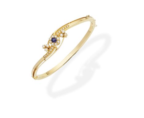 SEED PEARL AND SAPPHIRE BANGLEThe front designed as floral and foliate clusters of half pearls and a cushion-shaped sapphire,