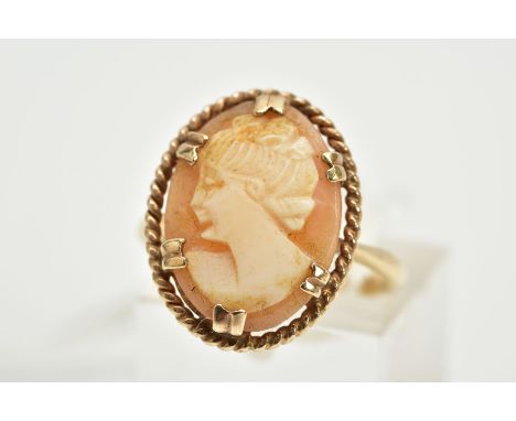 A YELLOW METAL CAMEO RING, the claw set cameo of oval design, depicting a lady in profile, within a rope twist surround, tape