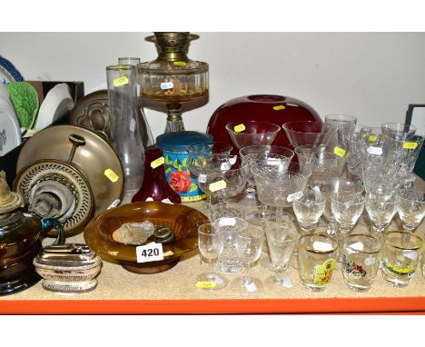 A GROUP OF GLASSWARE, etc, including three various oil lamps, a red glass light shade, a vintage Cadbury's Roses tin, a Ronso