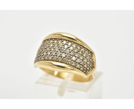 A YELLOW METAL DRESS RING, designed as a slightly curved panel set with colourless stones assessed as paste, stamped 'Design 