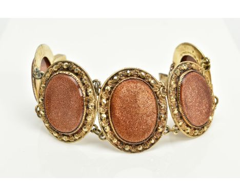 A SILVER GILT, GOLD STONE BRACELET, designed with five large oval links, each set with an oval panel of goldstone within a co