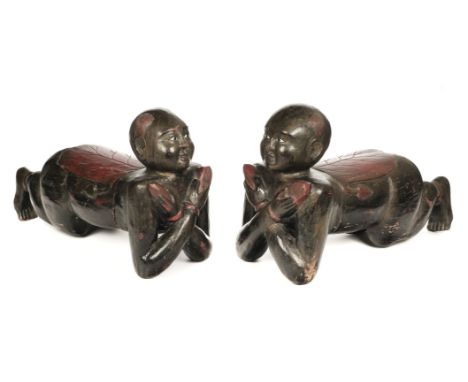 * Footstools. Pair of Chinese hardwood footstools, probably late 19th century, carved as recumbent boy servants each holding 