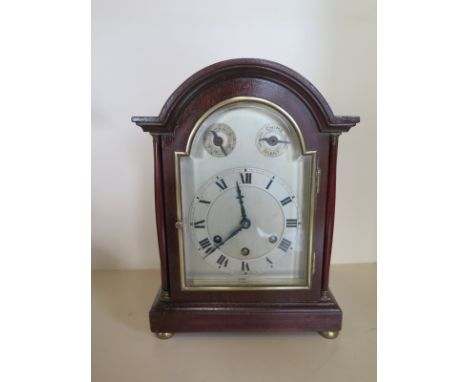 A mahogany case 8 day mantle clock three train movement, quarter chimes, silvered dial with strike, silent and fast slow dial