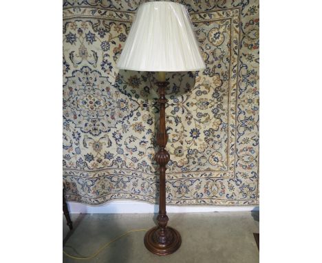 A 20th century walnut standard lamp with a decorative fluted column and new shade, overall height approximately 172cm, in a r