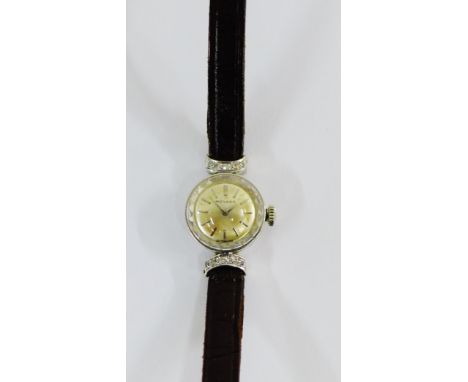 Lady's vintage Movado wristwatch in a white metal case, stamped indistinctly, with diamonds to the lugs, on a black leather s