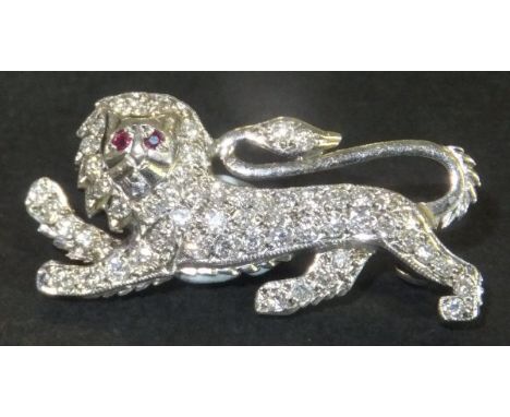 An 18 carat white gold brooch in the form of a lion passant, set with diamonds and ruby eyes, bears Millenium hallmark to bac