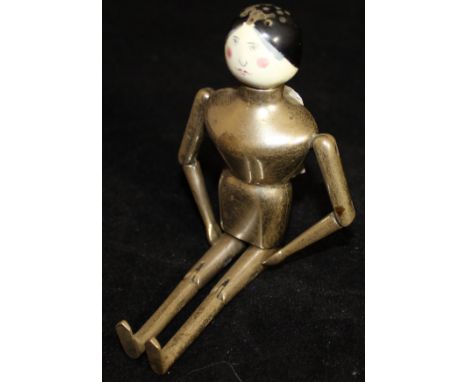 An Edwardian silver bodied pepperette in the form of an articulated Aunt Sally style doll with enamelled head (by Louis Willm