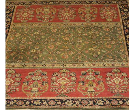 An Oriental carpet, the central rectangular panel with all over floral spray decoration on a green ground, flanked by two rec
