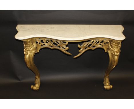 A Louis XV style console table with serpentine fronted marble top on a carved and pierced giltwood base to two carved scroll 