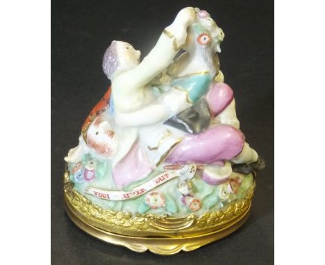 A snuff box (probably Berlin) in the form of a cavorting couple in 18th Century dress, set on a floral decorated mound with s