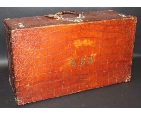 An early 20th Century Louis Vuitton crocodile skin covered suitcase with three locks, the central one marked "Patent Louis Vu