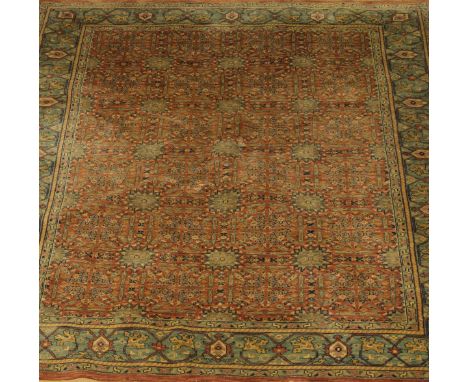 A Chobi carpet, the central field with repeating star medallions in duck egg blue, cream and pale terracotta, on a pale terra