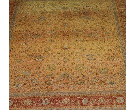 A Persian carpet, the central salmon field with all over floral and foliate decoration, within red, blue, cream and salmon sc