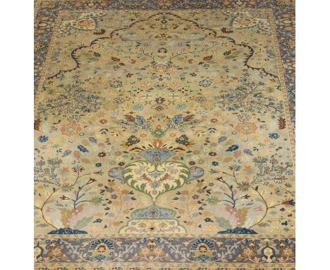 An Oriental carpet, the central field with vase and flower decoration in cream, green, pink, blue and pale cinnamon, on a sil