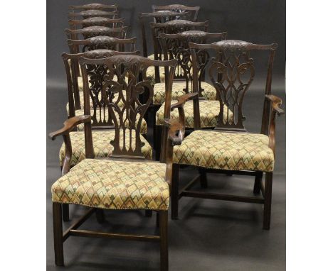 A set of twelve mahogany dining chairs in the Chippendale taste with pierced vase shaped back splats and upholstered seats wi