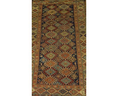 A Shirvan runner, the central diamond shaped medallions in terracotta, green, blue and pale gold, within multi-coloured geome