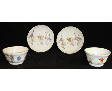 A pair of Chinese Qianlong tea bowls and saucers of ribbed form, each decorated with figures in an interior setting, some pla