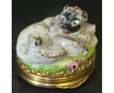 A late 18th Century (possibly Berlin) patch box in the form of a pug with pink bow and three pups seated on a floral decorate