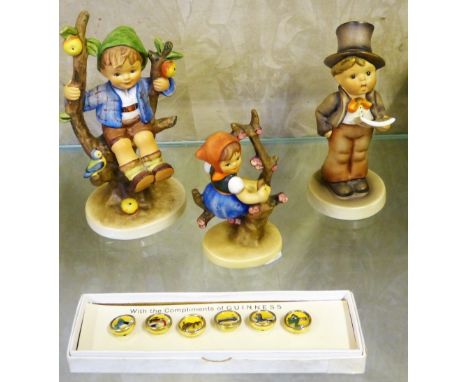 A boxed set of Guinness buttons together with three Hummel figures