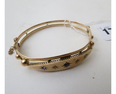 A 9ct gold bangle inset with blue and white stones