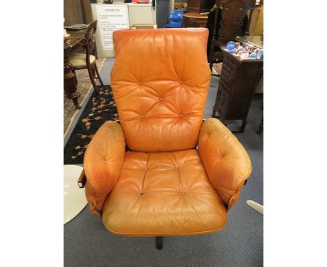 A Gote Mobler of Sweden, a brown leather upholstered, button back vinyl lounge chair having a teak frame and rosewood five st