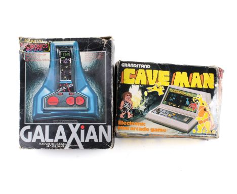 Two vintage electronic portable arcade games. Comprising Cave Man by Grandstand Leisure Products and Galaxian by Bandai, both